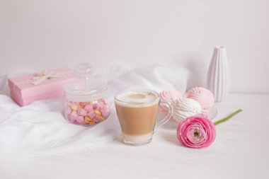 Pembe günaydın kartı. Bir fincan kahve, bir lokum ve açık ahşap arka planda pembe bir çiçek..