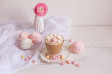 Pembe günaydın kartı. Bir fincan kahve, bir lokum ve açık ahşap arka planda pembe bir çiçek..