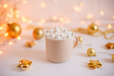 Bir kupa kahve ve lokum. Parlayan ışıkların üzerinde altın Noel topları var. Yeni yıl satış konsepti