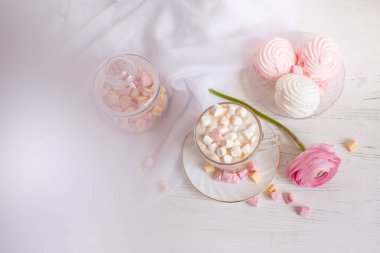 Pembe günaydın kartı. Bir fincan kahve, bir lokum ve açık ahşap arka planda pembe bir çiçek..