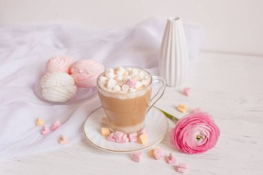 Pembe günaydın kartı. Bir fincan kahve, bir lokum ve açık ahşap arka planda pembe bir çiçek..