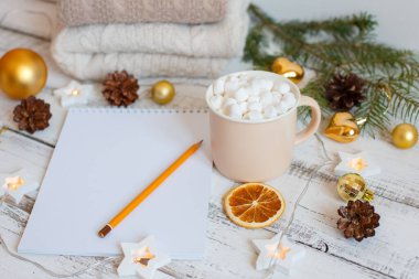 Noel arkaplanı, kalem, kahve fincanı ve şekerlemeli Not Defteri, Altın Noel ağacı oyuncakları. Noel Baba 'ya mektup. Mutlu Noeller tebrik kartı.