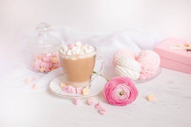 Pembe günaydın kartı. Bir fincan kahve, bir lokum ve açık ahşap arka planda pembe bir çiçek..