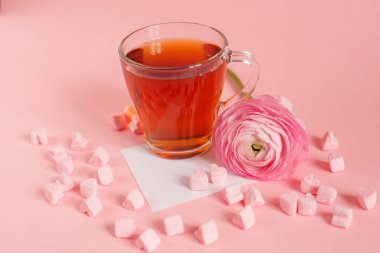 Kalp şeklinde lokum, gül ve kağıt kaplı bir fincan çay.