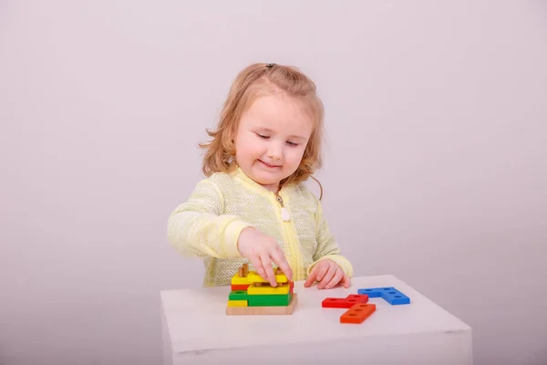 一个可爱的金发小女孩在一个白色背景的建筑商里玩耍 学前教育的概念 — 图库照片