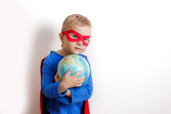 Happy super hero boy holding a globe in his hand, the concept of saving the world on a white background