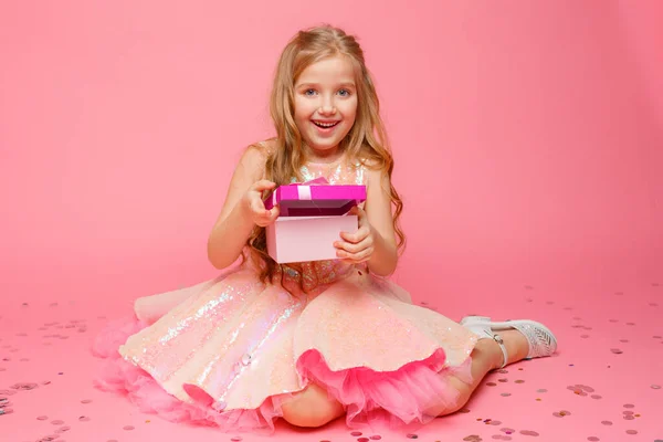 Ein Kleines Mädchen Mit Einem Geschenk Der Hand Lächelt Auf — Stockfoto