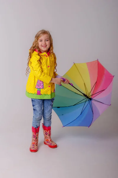 Schattig Klein Meisje Poseren Studio Gele Regenjas Met Regenboog Paraplu — Stockfoto