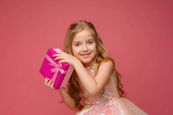 Una Bambina Che Tiene Mano Regalo Sorride Uno Sfondo Rosa — Foto Stock