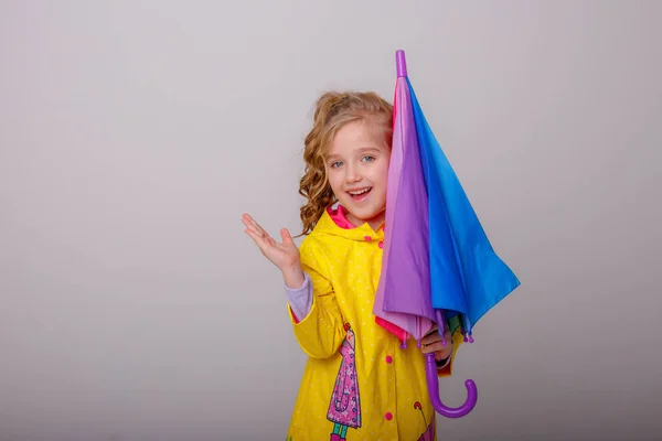 Linda Niña Posando Estudio Impermeable Amarillo Con Paraguas Arco Iris — Foto de Stock