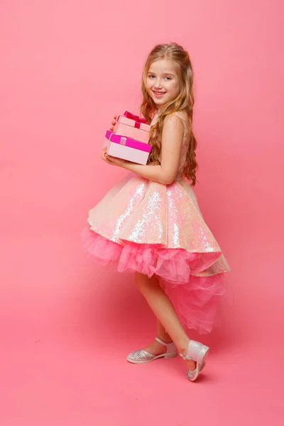 Маленька Дівчинка Тримає Подарунки Руках Посміхається Рожевому Фоні — стокове фото