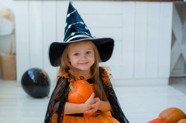 Cadılar Bayramı 'nda cadı kostümü giymiş küçük bir kızın portresi.