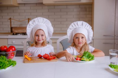 Masada sebzeli şef şapkası takan iki komik kız.