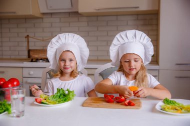Masada sebzeli şef şapkası takan iki komik kız.