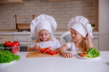 Masada sebzeli şef şapkası takan iki komik kız.