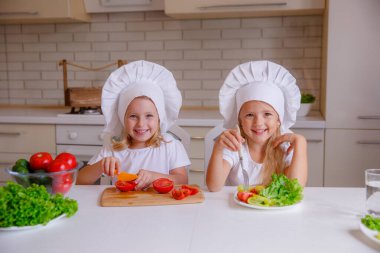 Masada sebzeli şef şapkası takan iki komik kız.
