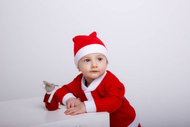 Fare oyuncağıyla küpün yanında poz veren sevimli küçük çocuk. 