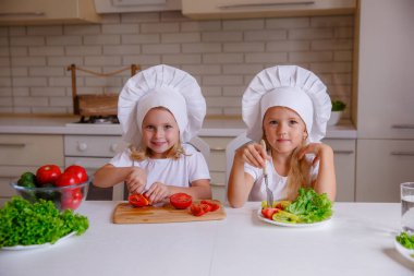 Masada sebzeli şef şapkası takan iki komik kız.