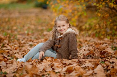 Sonbahar parkında poz veren neşeli çocuk