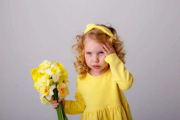 Ένα Μικρό Σγουρομάλλικο Κορίτσι Ένα Κίτρινο Φόρεμα Κρατώντας Ένα Μπουκέτο — Φωτογραφία Αρχείου