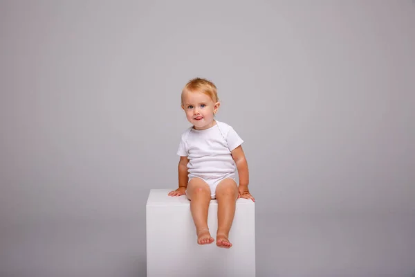 Menina Posando Estúdio Contra Fundo Cinza Sentado Cubo — Fotografia de Stock