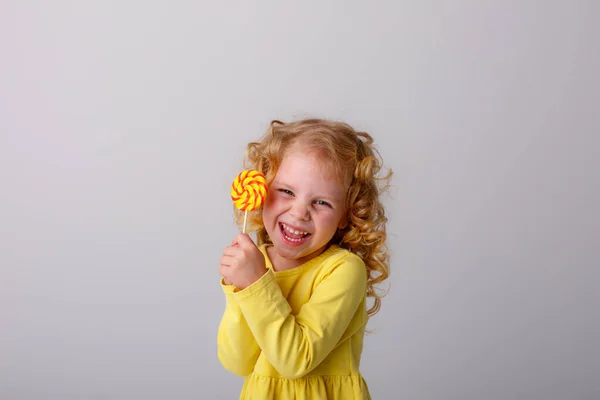 Kleines Lockiges Mädchen Posiert Mit Einem Lutscher Auf Grauem Hintergrund — Stockfoto