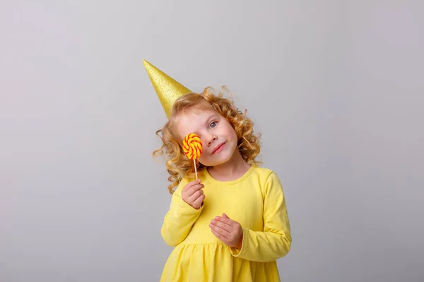 Pequena Menina Cabelos Encaracolados Com Chapéu Aniversário Segurando Pirulito — Fotografia de Stock