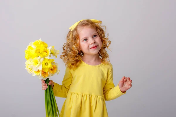 Een Klein Gekruld Meisje Een Gele Jurk Met Een Boeket — Stockfoto