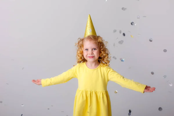 Menina Vestido Amarelo Pegando Confete Fundo Cinza — Fotografia de Stock