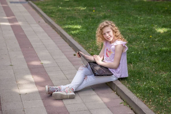 公園でノートパソコンを使う10代の女の子 — ストック写真