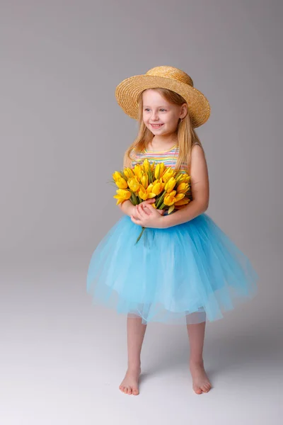 Mignonne Petite Fille Posant Studio Avec Des Tulipes Jaunes — Photo