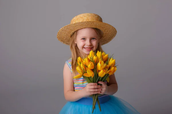 Mignonne Petite Fille Posant Studio Avec Des Tulipes Jaunes — Photo