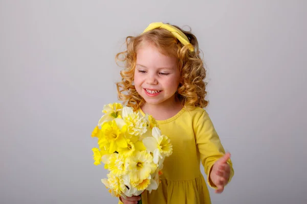 Malá Kudrnatá Dívka Žlutých Šatech Kyticí Jarních Květin — Stock fotografie