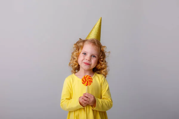 Pequeña Chica Pelo Rizado Con Sombrero Cumpleaños Sosteniendo Una Piruleta — Foto de Stock