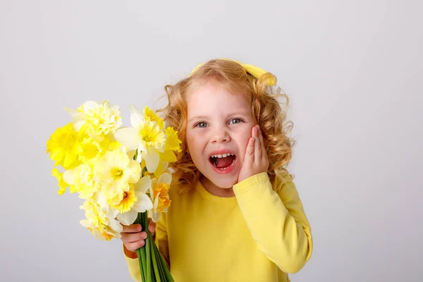 Egy Kis Göndör Hajú Lány Sárga Ruhában Egy Csokor Tavaszi — Stock Fotó