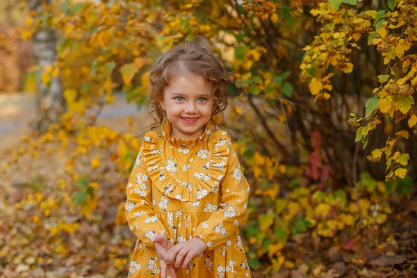 Bella Bambina Vestita Con Abito Arancione Posa Nel Parco Autunnale — Foto Stock