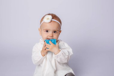 Beyaz tişörtlü ve açık arkaplanda mavi gözlü tatlı bir oğlan çocuğu.