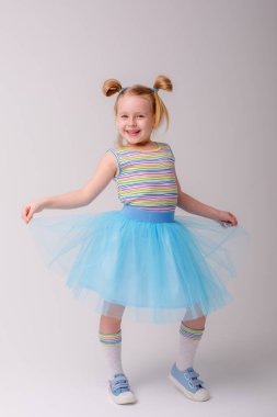 Stüdyoda Gray 'e karşı poz veren tatlı küçük kız. 