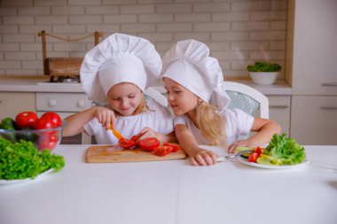 Masada sebzeli şef şapkası takan iki komik kız.