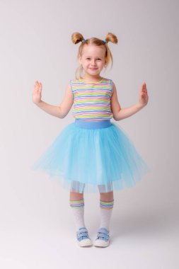 Stüdyoda Gray 'e karşı poz veren tatlı küçük kız. 