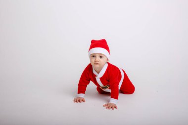 Stüdyoda Noel Baba kostümü giymiş şirin bir çocuk.