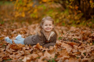 Sonbahar parkında poz veren neşeli çocuk