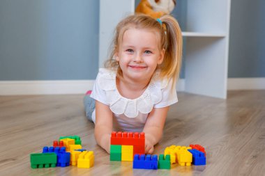 Kız evde inşaatçılık oynuyor.