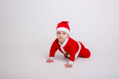 Stüdyoda Noel Baba kostümü giymiş şirin bir çocuk.