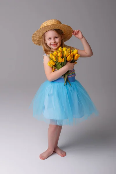 Mignonne Petite Fille Posant Studio Avec Des Tulipes Jaunes — Photo