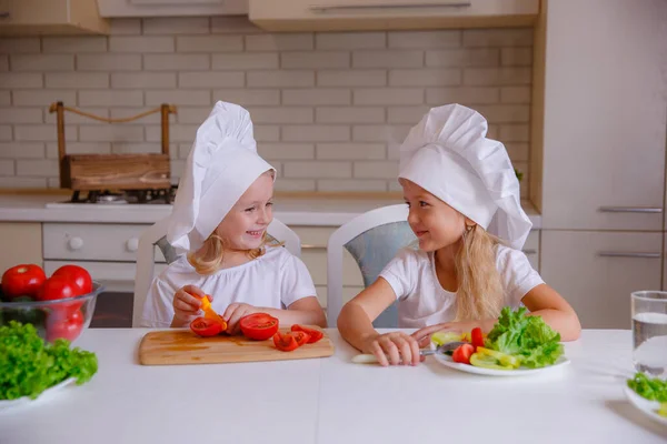Две Милые Смешные Девушки Позируют Шляпах Шеф Повара Овощами Столе — стоковое фото