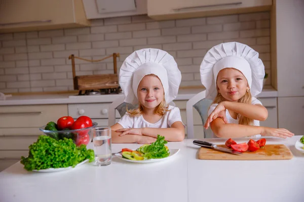 Две Милые Смешные Девушки Позируют Шляпах Шеф Повара Овощами Столе — стоковое фото