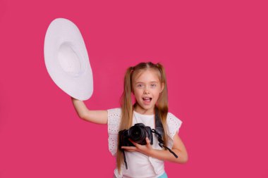 Portrait of a girl traveler about traveling camera in hand Studio on a pink background clipart