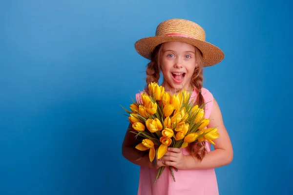 Egy Szalmakalapot Viselő Kislány Egy Csokor Sárga Tulipánt Tart Kék — Stock Fotó