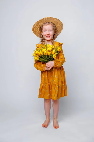 Niña Vestido Amarillo Con Ramo Flores Sobre Fondo Blanco — Foto de Stock